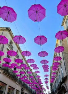 Parapluies roses suspendus au dessous de la Rue de la loge à Montpellier